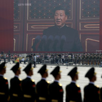 A huge screen shows Chinese President Xi Jinping delivering a speech at the start of a parade to mark the 70th anniversary of the founding of the People's Republic of China, in Beijing, Tuesday, Oct. 1, 2019. (AP Photo/Mark Schiefelbein)