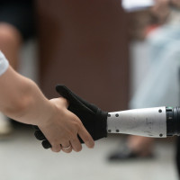 A general view shows a handshake between a human and a humanoid robot at the Shanghai New Expo Center during the opening day of the World Artificial Intelligence Conference (WAIC) 2025 in Shanghai, China, on July 26, 2025.