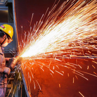 A worker is producing wind turbine towers in a workshop of a wind power equipment enterprise in Lianyungang Economic and Technological Development Zone, Jiangsu Province, China