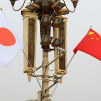 Chinese and Japanese flags flutter in the wind.