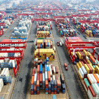 Vehicles are loading containers at Qingdao Port Foreign Trade Container Terminal in Shandong Province, China