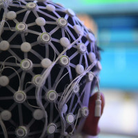 Person demonstrating a motor imagery brain-computer interface rehabilitation training system.