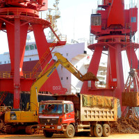 -An excavator loads a truck with rare earth on a quay at the Port of Lianyungang in Lianyungang city, east Chinas Jiangsu province, 10 March 2013.
