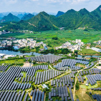 A vast array of deep-blue solar panels stretches across karst mountains at the Hongqi photovoltaic power base in Dahua Yao Autonomous County, Hechi, south China's Guangxi Zhuang Autonomous Region, Sept. 9, 2026, blending with scattered homes and farmland. (Photo by Imaginechina/Sipa USA)