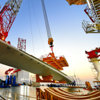 This photo taken on Jan. 13, 2026 shows one of the turbine blades being hoisted at the construction site of a 20-megawatt offshore wind turbine unit in the coastal waters of southeast China's Fujian Province. 