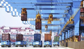Gantry cranes move containers onto transporters at a port in Qingdao in eastern China's Shandong province.