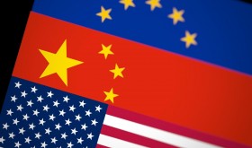 Blurred USA, China and EU flags together on black background