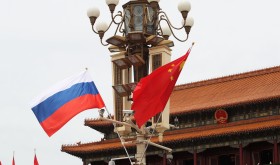 Chinese and Russian national flags flutter on a lamppost in front of the Tian'anmen Rostrum