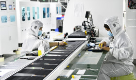 Workers at a liquid crystal display manufacturer work at Shanting Economic Development Zone in east China's Shandong province