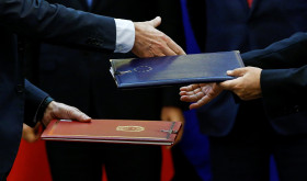 Chinese and European officials exchange documents.