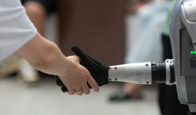 A general view shows a handshake between a human and a humanoid robot at the Shanghai New Expo Center during the opening day of the World Artificial Intelligence Conference (WAIC) 2025 in Shanghai, China, on July 26, 2025.