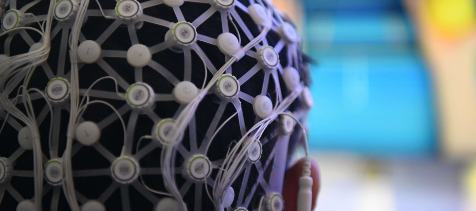 Person demonstrating a motor imagery brain-computer interface rehabilitation training system.