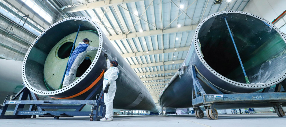 staff member uses intelligent inspection technology to check the quality of fan blades on the inspection line of Shanghai Electric's wind turbine blade production line, located in Nanhua Industrial Park, Gaotai County, Zhangye city, Gansu province, China, March 7, 2024.