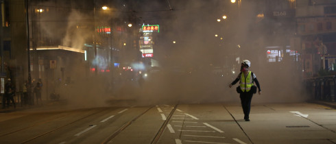 A journalist runs away from tear gas at Lan Kwai Fong, Hong Kong 