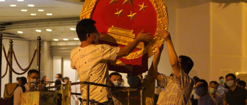 Workers place a national emblem outside the Metropark Hotel Causeway Bay