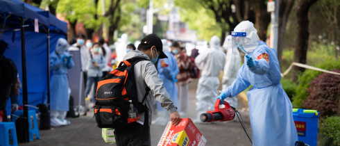 A staff member helps a villager disinfect baggage when he returns to Lianqin Village