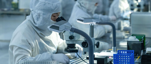 Technical workers produce and examine a mobile phone camera module at a dust-free workshop in Hefei, Anhui Province, China.