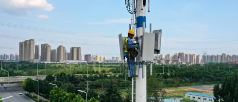 An employee of China Mobile Communications Group checks a 5G base station tower
