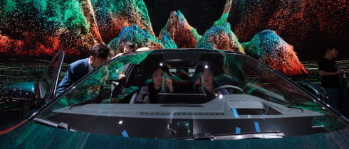 People sit in an EV car standing on display at the BYD company booth, during the second press day of the 20th Shanghai International Automobile Industry Exhibition, in Shanghai, China, 19 April 2023.