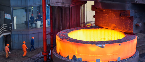 Chinese workers check a seamless forging piece at a forging workshop of CITIC Heavy Industries Company in Luoyang city, central China's Henan province