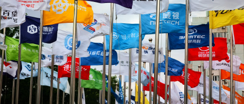 Factory flags of famous Chinese enterprises flutter in the wind under the blue sky in front of the square of the permanent site of the Zhongguancun Forum in Beijing, China, May 14, 2024.
