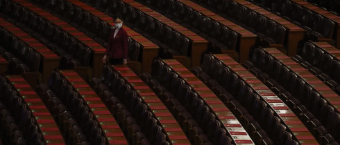 A hostess gives a final check on the reports placed on tables ahead of the closing session of the National People's Congress (NPC) at the Great Hall of the People in Beijing, Monday, March 11, 2024. 