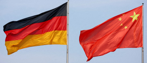 The flags of Germany and China are flying in the wind.