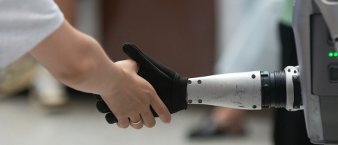 A general view shows a handshake between a human and a humanoid robot at the Shanghai New Expo Center during the opening day of the World Artificial Intelligence Conference (WAIC) 2025 in Shanghai, China, on July 26, 2025.