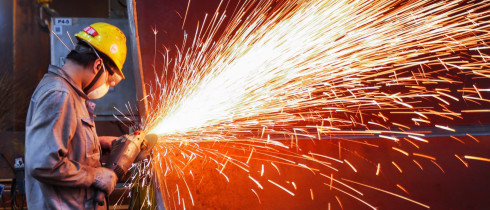 A worker is producing wind turbine towers in a workshop of a wind power equipment enterprise in Lianyungang Economic and Technological Development Zone, Jiangsu Province, China