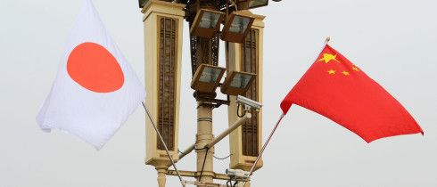 Chinese and Japanese flags flutter in the wind.