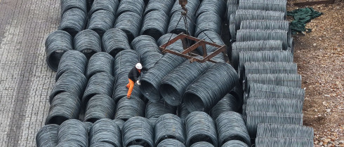 Steel is hoisted and stacked at a steel market in Hangzhou, Zhejiang province