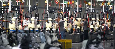Workers assemble electric two-wheelers at AIMA Technology's production line in Tongliang District, southwest China's Chongqing, June 17, 2026.