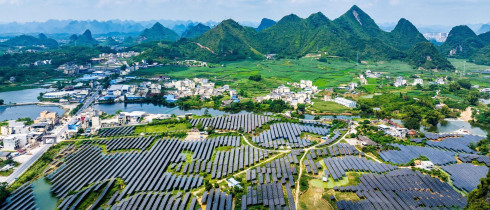 A vast array of deep-blue solar panels stretches across karst mountains at the Hongqi photovoltaic power base in Dahua Yao Autonomous County, Hechi, south China's Guangxi Zhuang Autonomous Region, Sept. 9, 2026, blending with scattered homes and farmland. (Photo by Imaginechina/Sipa USA)